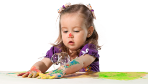 preschool girl playing with paints